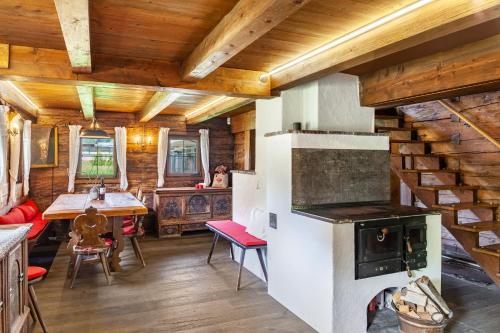a kitchen and dining room with a stove in a cabin at Altes Totschenhäusl am Ziller in Finsing