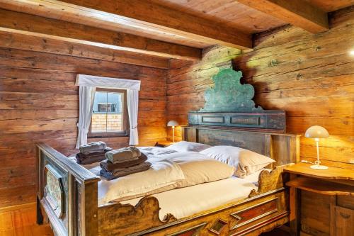 a bedroom with a bed in a room with wooden walls at Altes Totschenhäusl am Ziller in Finsing