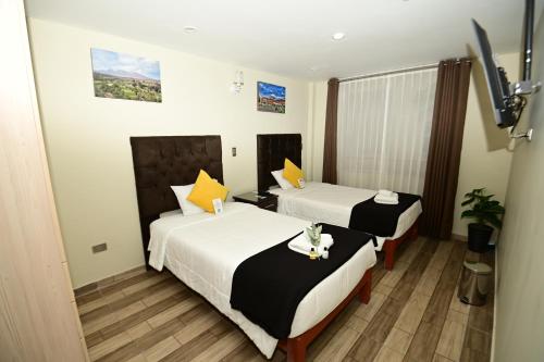 a hotel room with two beds and a tv at Bon Repos Boutique in Arequipa