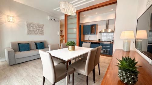 a dining room and living room with a table and chairs at Residence Lungomare - Charming apartments in Riccione