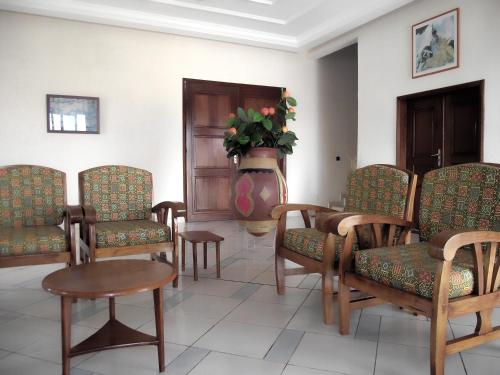 a waiting room with chairs and a vase of flowers at Hotel Ghis Palace in Baguida