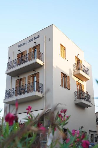 a white building with balconies and flowers in the foreground at Porta Harenae Residencia in Chania
