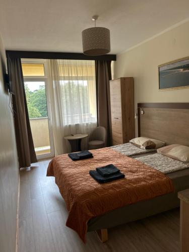 a bedroom with a bed with two towels on it at Kornelija in Palanga