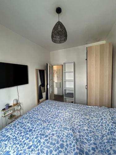 une chambre avec un grand lit avec une couverture bleue dans l'établissement Sejour paris parc des expositions, à Vanves