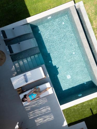 an overhead view of a woman in a swimming pool at Aphrodite Luxury Suites with private heated pools in Kos Town