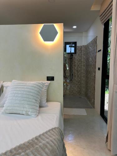 a bedroom with a bed and a walk in shower at Eterno Villas in Salad Beach
