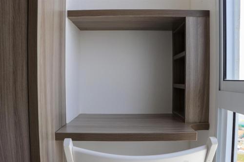 a room with a wooden shelf and a window at Homey Designed and Tidy Studio Tokyo Riverside PIK 2 Apartment By Travelio in Rawalembang