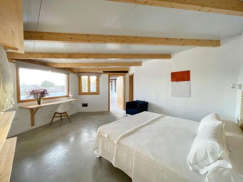 a bedroom with a large white bed and a desk at La Tierrua home in Tefía