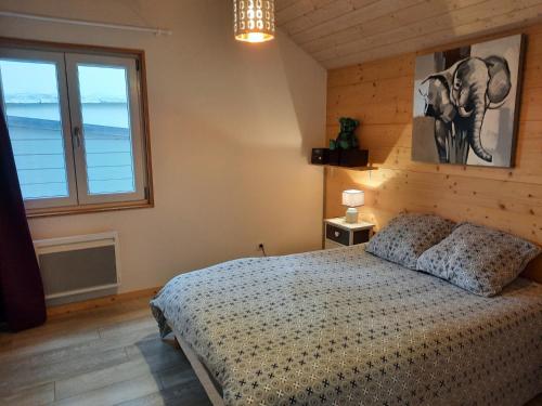 une chambre avec un lit et une grande fenêtre dans l'établissement L'Atelier, à Salins-les-Bains