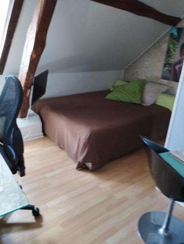 - une chambre mansardée avec un lit et un bureau dans l'établissement Maison Familiale, à Allonnes