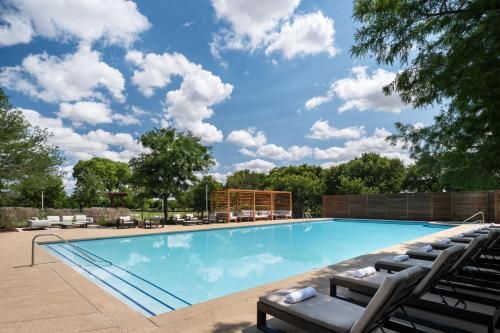a large swimming pool with lounge chairs around it at Dallas/Fort Worth Marriott Hotel & Golf Club at Champions Circle in Roanoke