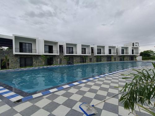 a large swimming pool in front of a building at Corbett Tusker Meadows by White Flower in Rāmnagar