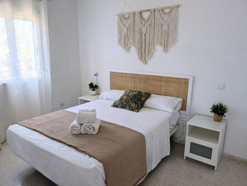 a bedroom with a large bed with towels on it at IslaOC Apartamentos - Apartamento 2 habitaciones primera línea Playa Central Isla Cristina in Isla Cristina