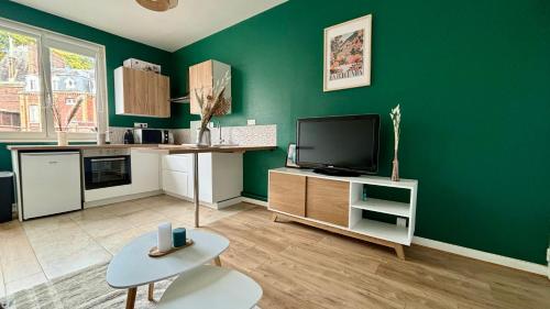 sala de estar con pared verde y TV en Appartement proche gare avec garage, en Rouen