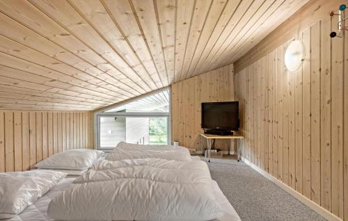 a room with four beds and a flat screen tv at Gorgeous Home In Væggerløse With Sauna in Marielyst