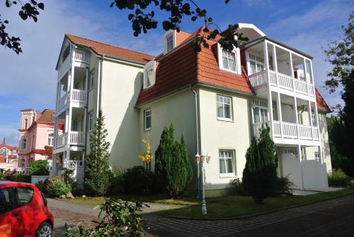 ein großes weißes Gebäude mit rotem Dach in der Unterkunft Fewo Rosenhof 13 in Kühlungsborn