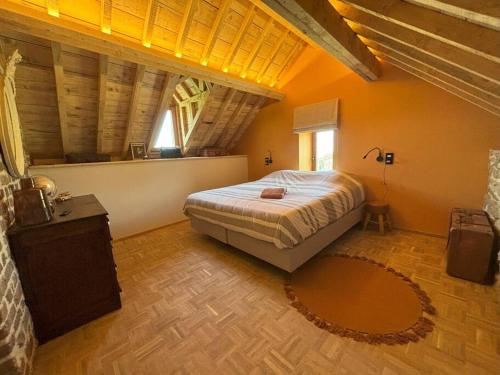 a bedroom with a large bed in an attic at La Petite Maison dans la Prairie in Pepinster