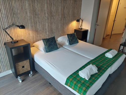 a bedroom with a bed with a green and white blanket at B&B Museumkwartier Schiedam in Schiedam