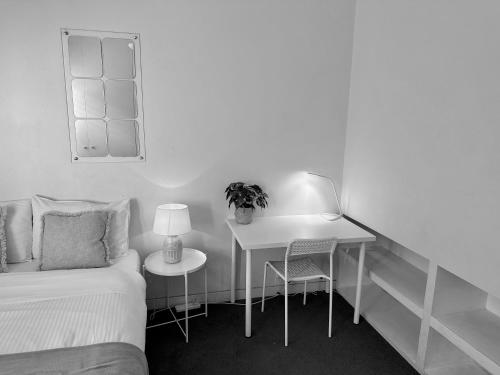 a bedroom with a bed and a desk with a plant at St Kilda Style - Stunning 3 Bedroom House in Melbourne