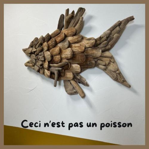 une main en bois faite de bâtons sur un mur dans l'établissement L'appart, à Bandol