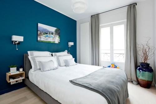 une chambre avec un grand lit blanc avec des murs bleus dans l'établissement Appartement de luxe 1 chambre Tour Eiffel avec balcon, à Paris