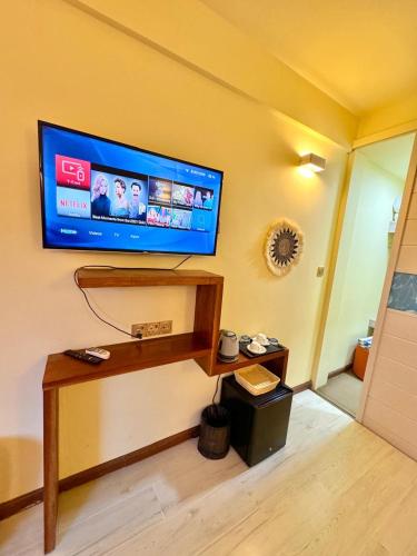 a living room with a tv on the wall at Sands Grand in Dhigurah