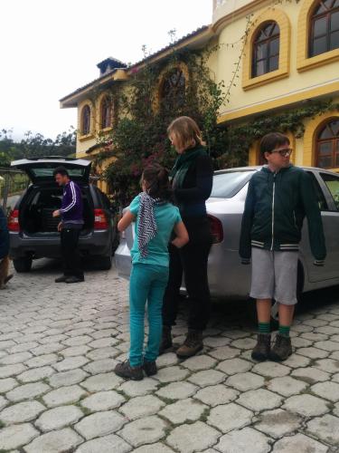 a group of people standing next to a car at Hostal Curiñan in Otavalo