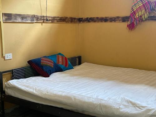 a bed with two pillows on it in a room at Loop Top Đồng Văn Homestay in Dồng Văn