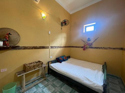 ein kleines Schlafzimmer mit einem Bett und einem Fenster in der Unterkunft Loop Top Đồng Văn Homestay in Dồng Văn