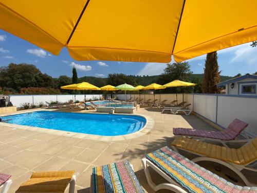 une piscine avec chaises et parasols dans l'établissement Le Petit Paradis Provençal, à Allemagne-en-Provence