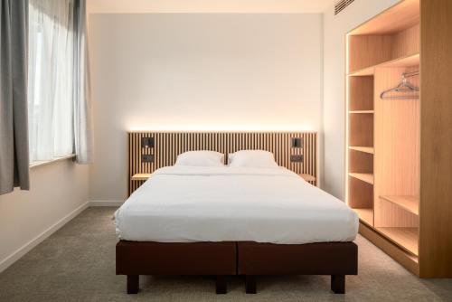 a bedroom with a large bed with white sheets at Hotel Chamade in Ghent