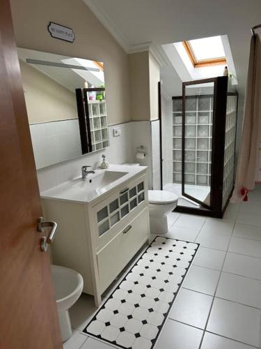 a bathroom with a sink and a toilet and a mirror at Dúplex con vistas al mar in Baiona