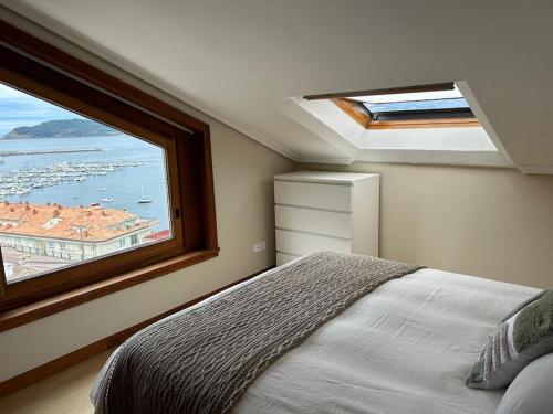 a bedroom with a bed and a large window at Dúplex con vistas al mar in Baiona