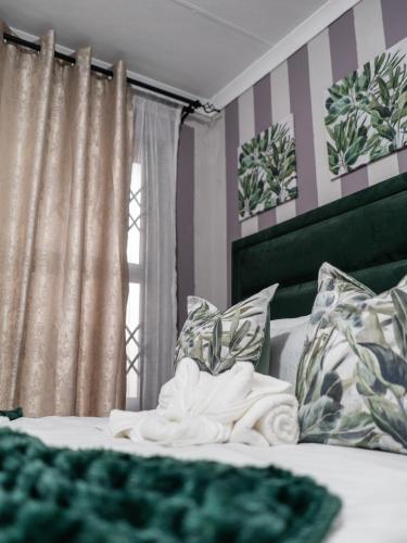a bedroom with a bed with striped walls and a window at Plein On Suid Guesthouse in Polokwane