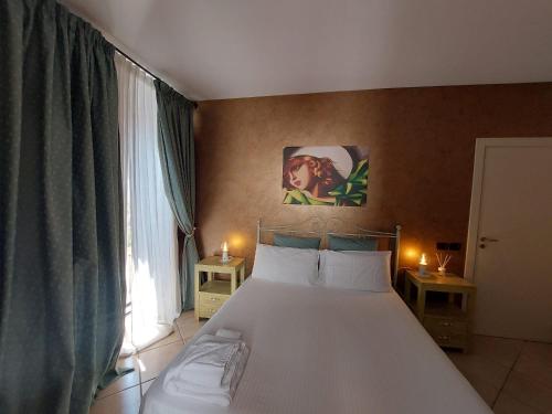 a bedroom with a large white bed with two lamps at B&B Il Grifone in Gioia del Colle