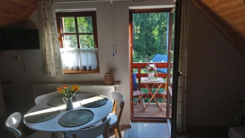a dining room with a table and chairs and a balcony at Apartmán Stodola2 Harrachov in Harrachov