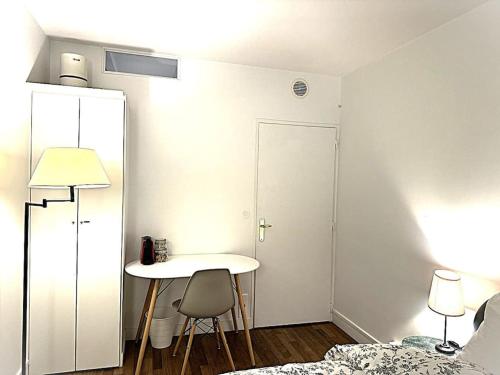 une pièce avec une table et un lit et une table et des chaises dans l'établissement A cozy Parisian apartment close to Eiffel Tower, à Paris