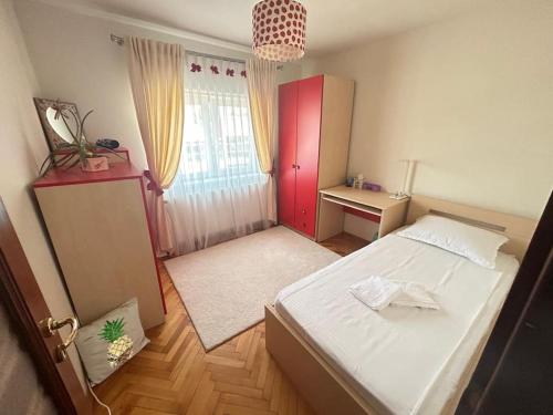 a bedroom with a white bed and a red cabinet at Apartament in Lugoj Gabriela in Lugoj