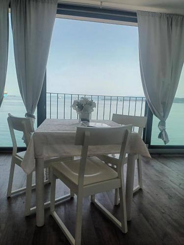 a white table and chairs with a view of the ocean at VILA MOLET KOPER in Koper