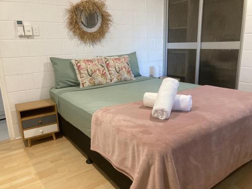 a bedroom with a bed with two towels on it at Withanee in Picnic Bay