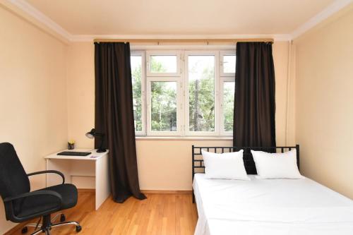 a bedroom with two beds and a chair and a window at Cozy appartement in big center in Yerevan