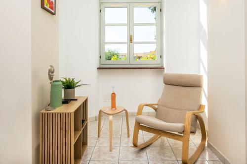 un salon avec une chaise et une table dans l'établissement OLIVIERS -Agréable 2 pièces dans maison bourgeoise, à Menton