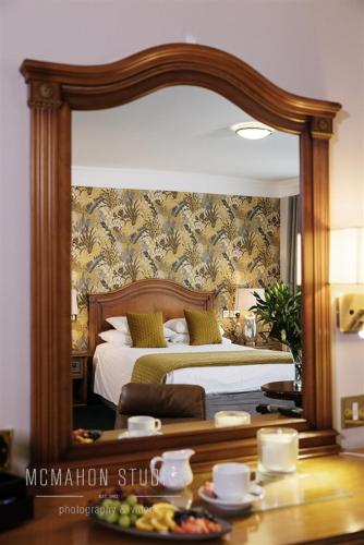 a large mirror in a bedroom with a bed at Corbett Court in Fermoy