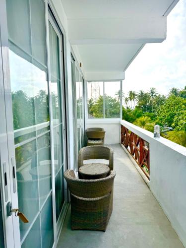 a balcony with a chair and some windows at Sands Grand in Dhigurah