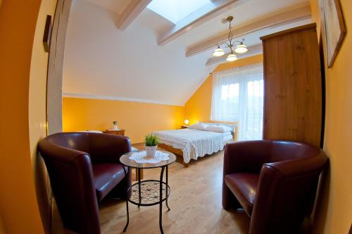 a bedroom with a bed and two chairs and a table at Willa pod Czantorią SPA Ustroń in Ustroń