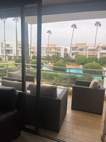 a lobby with couches and a view of a pool at Résidence calme et luxueuse in Dar Bouazza