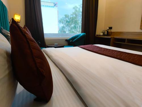a hotel room with a bed and a desk and a window at Hotel W Grand - A Boutique Hotel in Haridwār