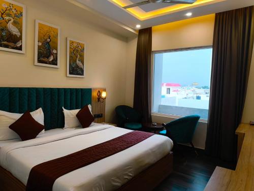 a hotel room with a bed and a large window at Hotel W Grand - A Boutique Hotel in Haridwār