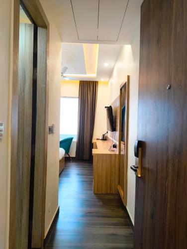 a hallway of a hotel room with a desk and a television at Hotel W Grand - A Boutique Hotel in Haridwār