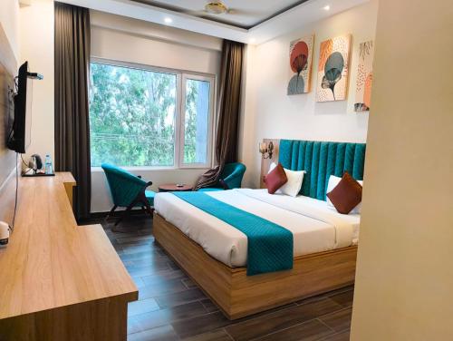 a hotel room with a bed and a window at Hotel W Grand - A Boutique Hotel in Haridwār